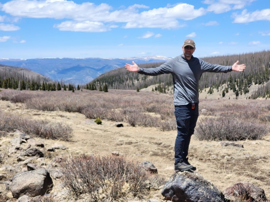 Captain Stingray on a mountain overlook with arms wide open