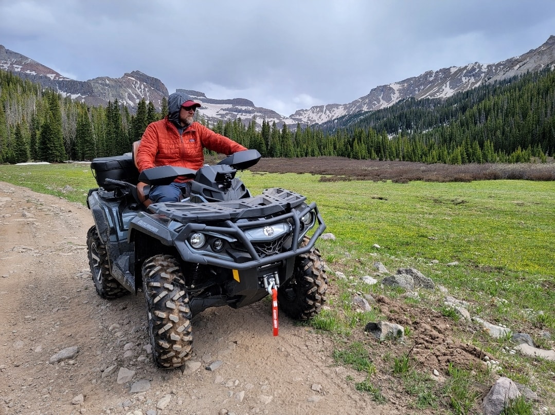 Captain Stingray riding an ATV in the mountains